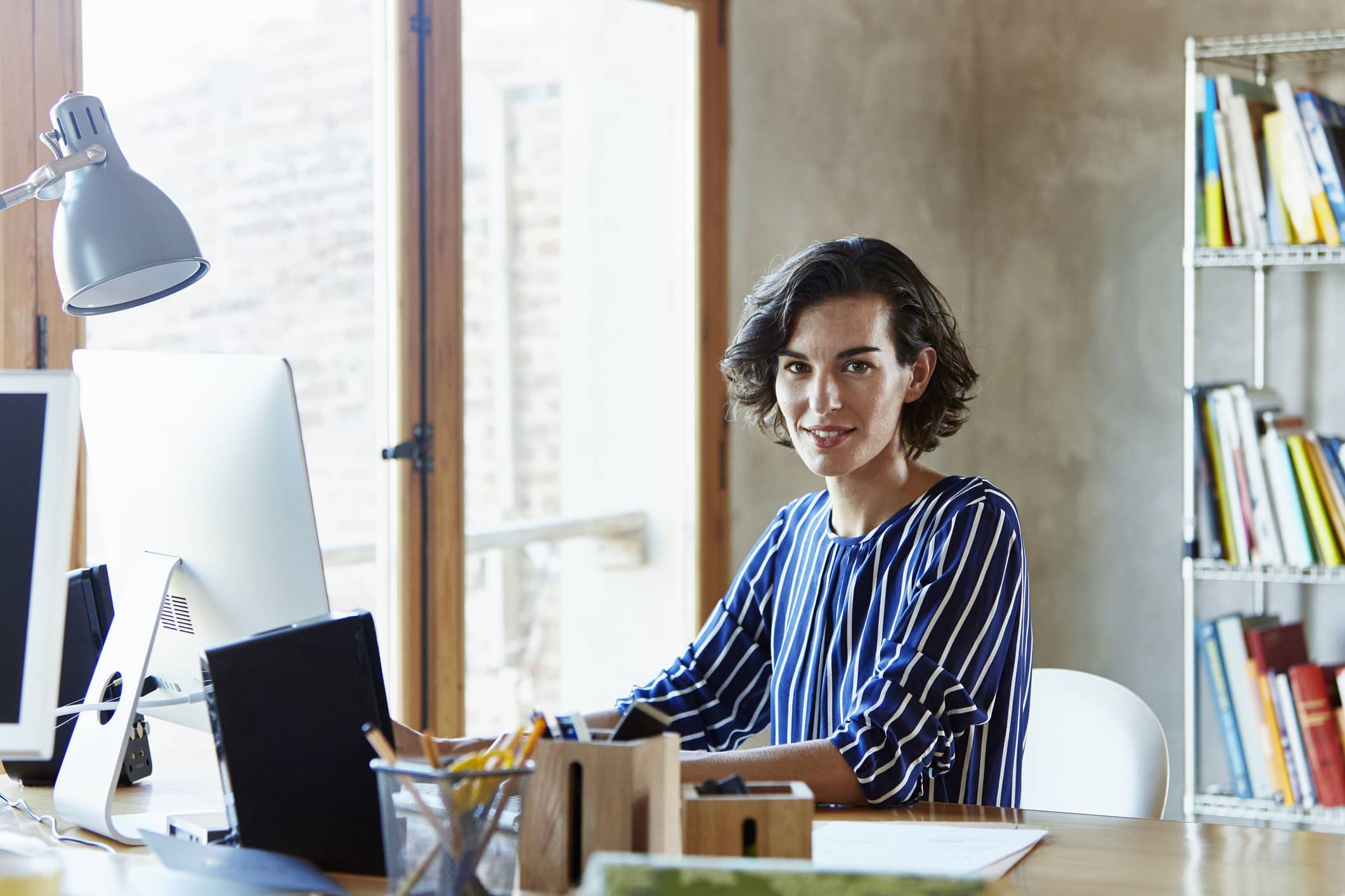 Creative Businesswoman Sitting At Desk In Office