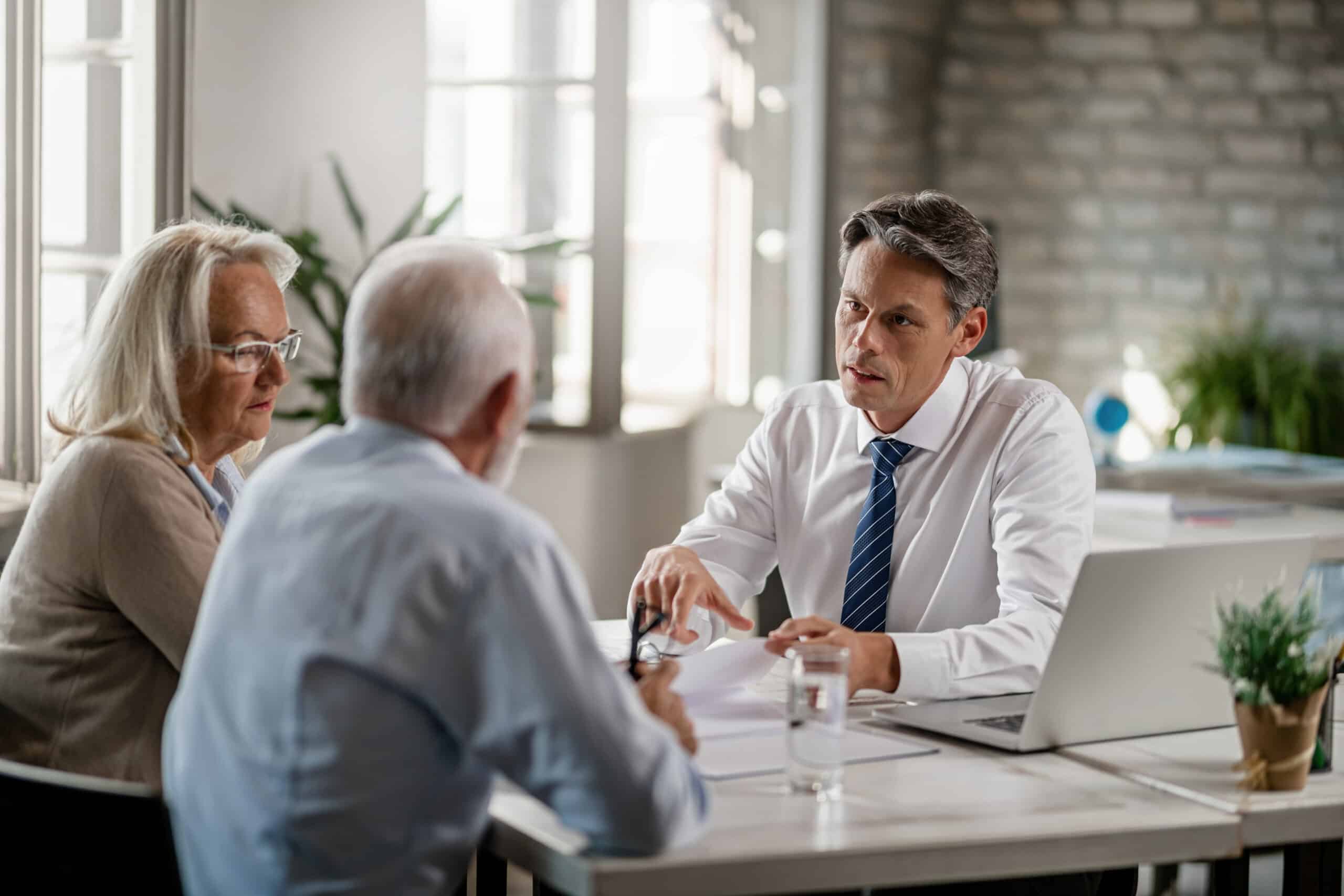 Financial advisor and senior couple talking while going through